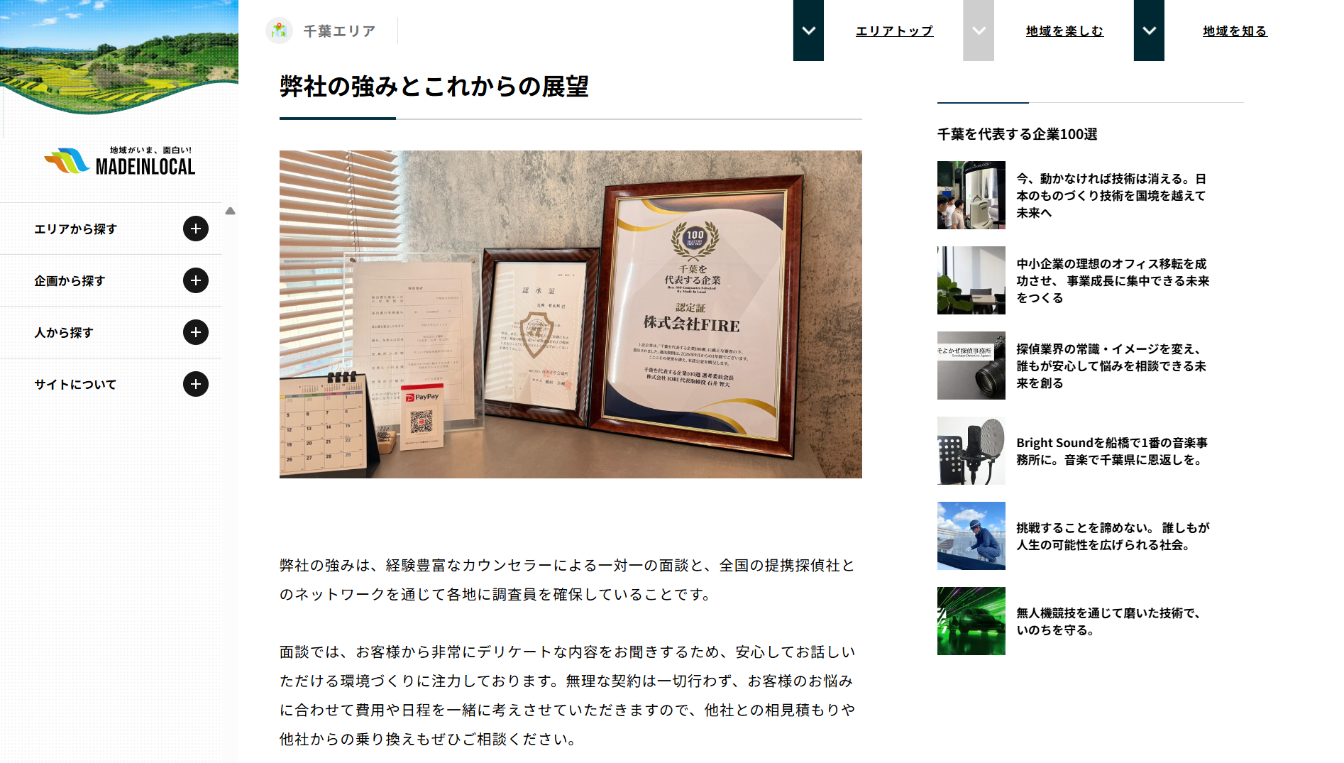 Framed certificates and an award plaque displayed on a desk beside a calendar and documents against a textured wall.