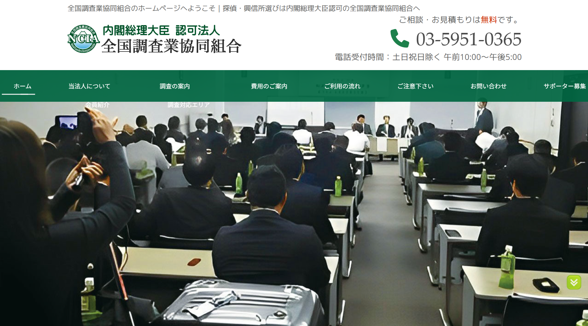 Conference room filled with professionals seated in rows, listening to a panel at the front.